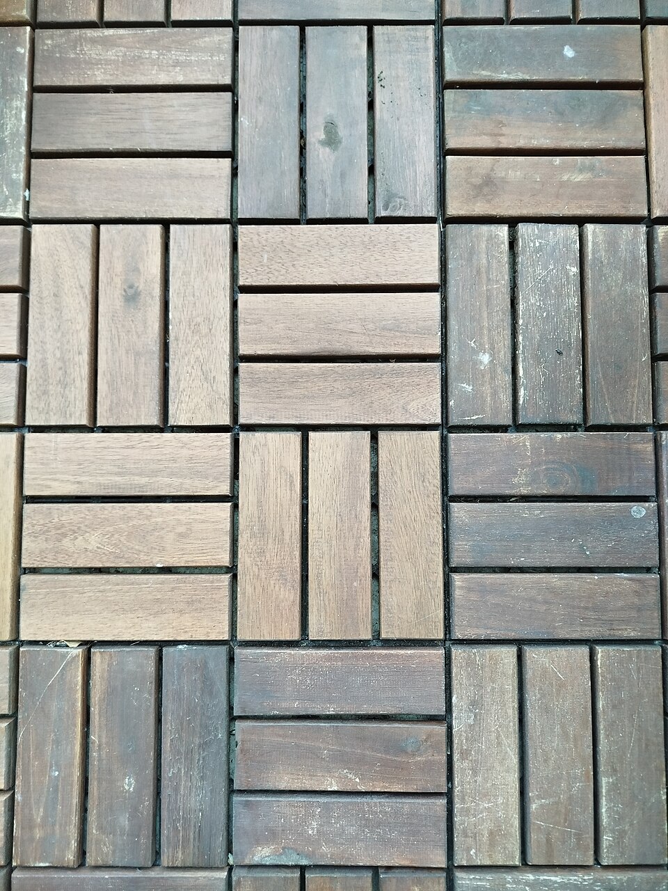 Dalles de bois assemblées en motif pour former un revêtement de terrasse modulaire