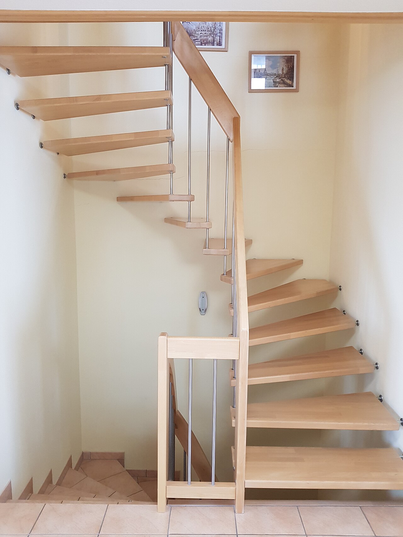 Escalier intérieur en bois à marches ouvertes, avec main courante et garde-corps.