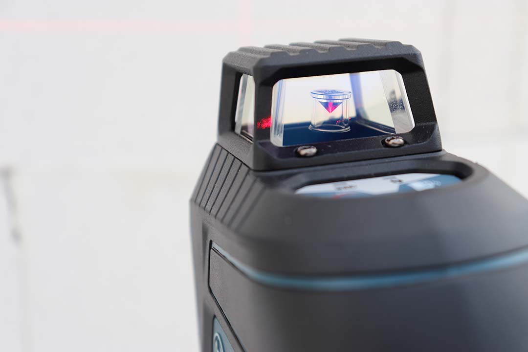 Partie supérieure d’un niveau laser avec fenêtre optique protégée par une armature.