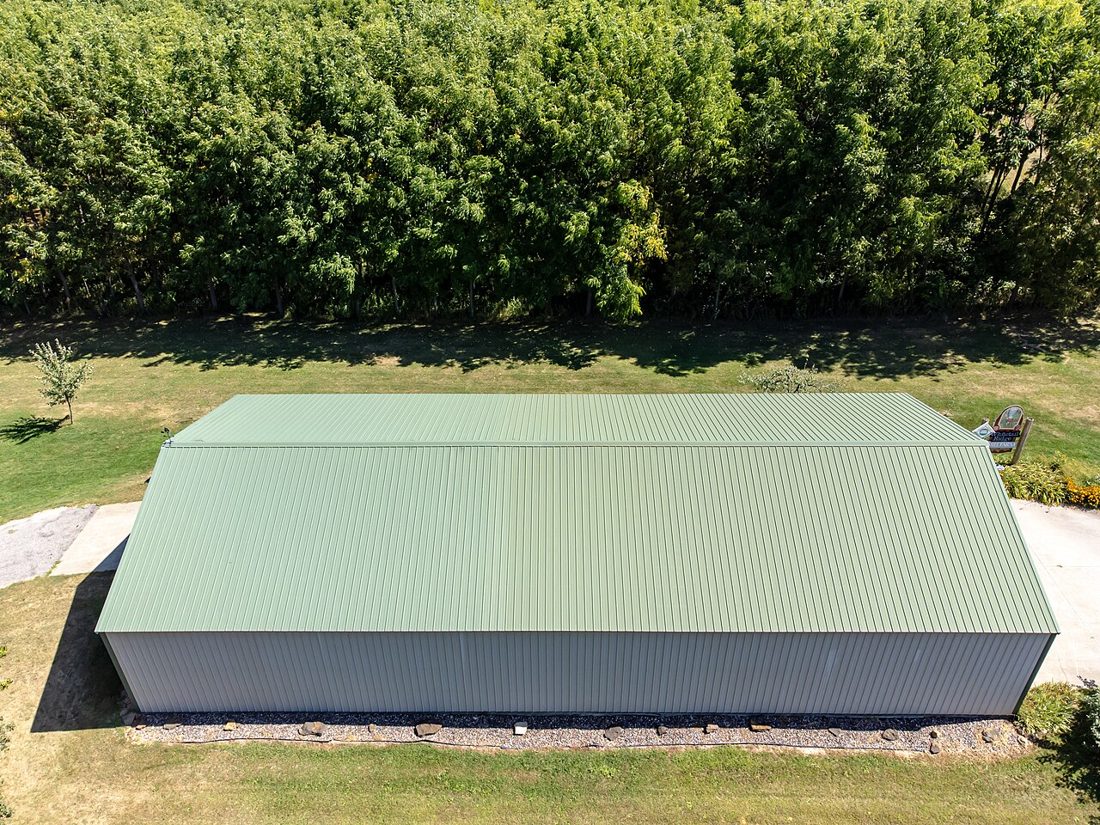 Vue d'ensemble d'une toiture en plaques métalliques nervurées, de couleur vert clair